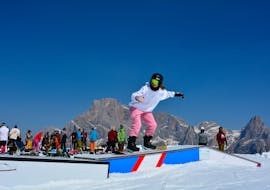 A rider tries new tricks at the snowpark of San Martino di Castrozza during the Private Snowboarding Lessons for All Levels with Scuola Italiana Sci Dolomiti San Martino di Castrozza.