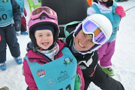 Een instructeur en een kind tijdens de skilessen voor kinderen (vanaf 4 jaar) voor alle niveaus met Scuola Italiana Sci Arabba.