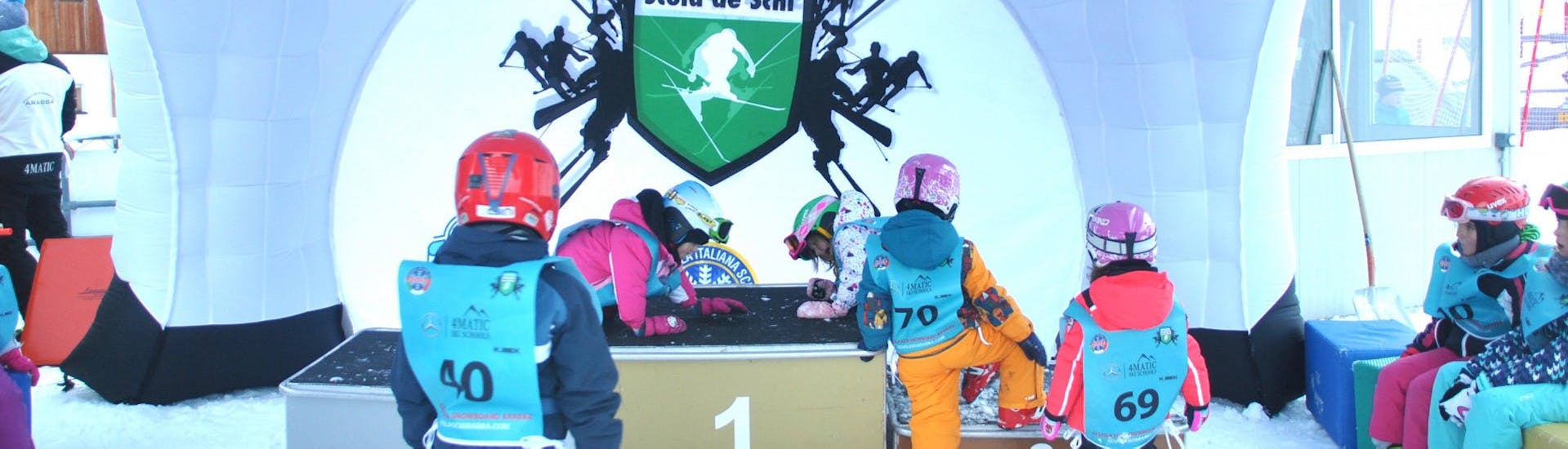 Piccoli sciatori si divertono nel kinderland durante le Lezioni di sci per bambini (dai 4 anni) per tutti i livelli con Scuola Italiana Sci Arabba.
