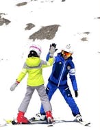 Een skiër en zijn leraar tijdens de Privé Skilessen (vanaf 4 jaar) voor Kinderen van Alle Niveau's bij Scuola Italiana Sci Folgaria-Costa.