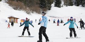 Ein Skifahrer und ein Skilehrer während des Snowboard-Privatkurses für alle Levels mit der Scuola Italiana Sci Folgaria-Costa.