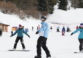 Uno snowboarder con il suo istruttore durante le Lezioni private di snowboard per tutti i livelli  con Scuola Italiana Sci Folgaria-Costa.