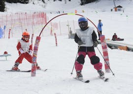 Un groupe d'enfants skiant avec le moniteur pendant les cours de ski pour enfants (4-5 ans) pour débutants avec la Scuola Italiana Sci Folgaria-Fondo Grande.