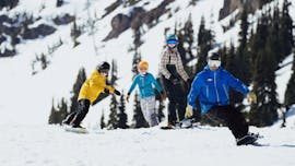 Alcuni partecipanti fanno una discesa con il loro istruttore durante le Lezioni private di snowboard per tutte le età e livelli con Scuola Italiana Sci Folgaria-Fondo Grande.