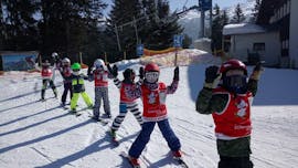 Niños levantando las manos con Skischool Glungezer