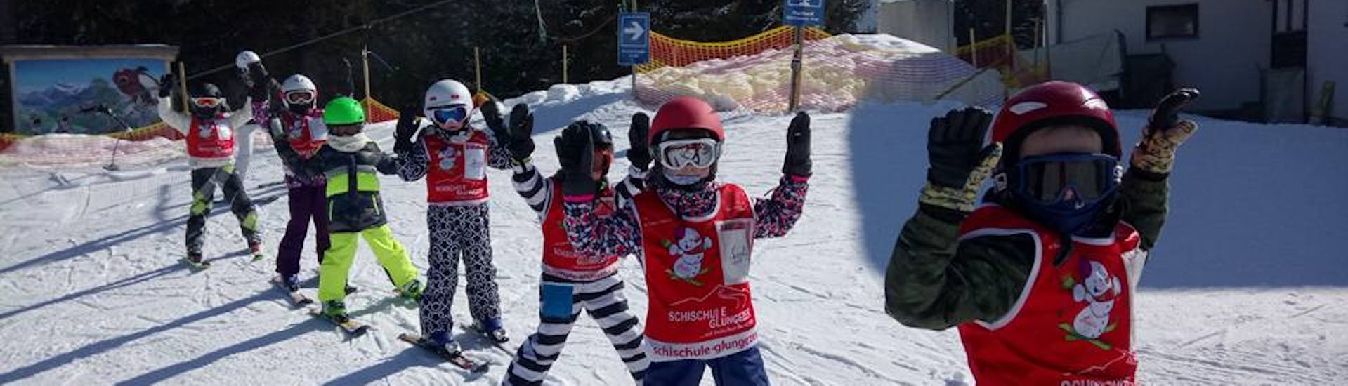 Children holding their hands in the air with Skischool Glungezer