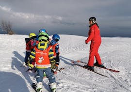 Niños en fila durante las clases de esquí para niños para esquiadores experimentados con la escuela de esquí Glungezer Tulfes.