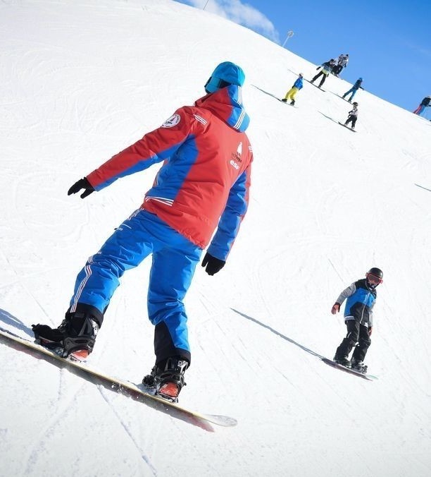 Un snowboardeur s'entraîne pendant un Cours particulier de snowboard pour Tous âges et niveaux avec ESF La Plagne.