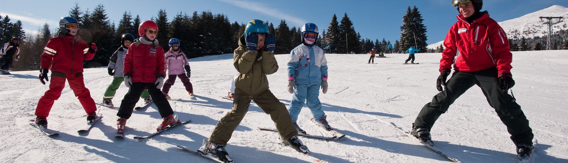 Kinder fahren im Schneepflug ab während des Kinder-Skikurs für Anfänger - Wochenende mit Skischule Nova.