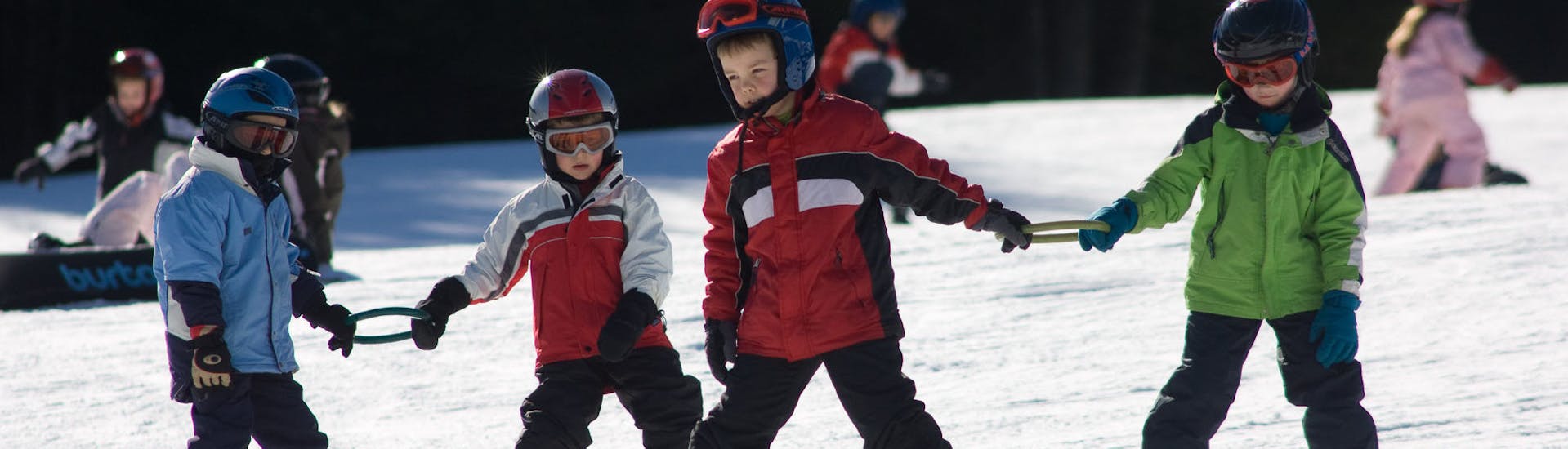 Kinderen houden ringen vast tijdens de kinderskilessen voor beginners met Skischool Nova.