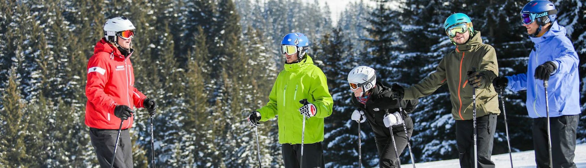 Skilehrer erklärt seiner Gruppe eine Übung während des Skikurs für Erwachsene für Anfänger - Wochenende mit Skischule Nova.