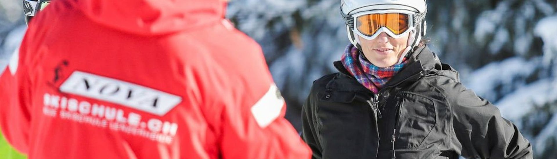 Un moniteur de ski donne des instructions aux élèves pendant les cours particuliers de ski pour adultes avec l'école de ski Nova.
