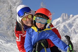 Beeld van een instructeur van de Skischool Monte Bianco met een kind op een piste in Courmayeur tijdens de Kinderskilessen (4-12 jaar) voor beginners.