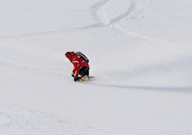 Beeld van een instructeur van de Skischool Monte Bianco Courmayeur tijdens de snowboardles (vanaf 5 jaar) voor alle niveaus.