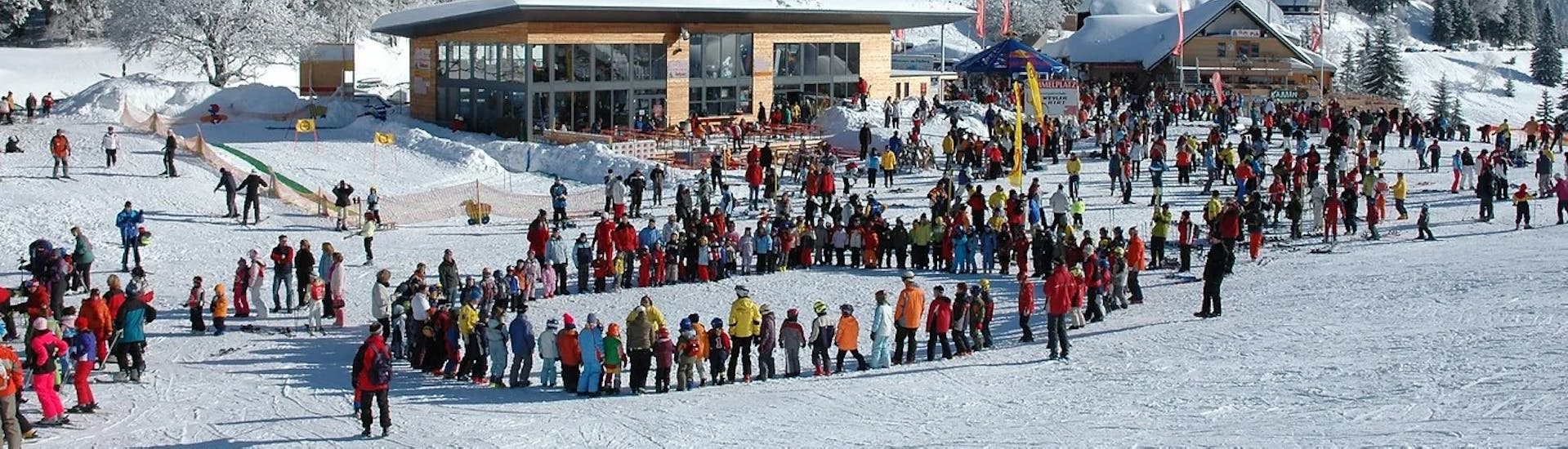 Kids in a circle warming up for the Kids Ski Lessons (from 3 y.) for Beginners with Schneesportschule ON SNOW Feldberg.