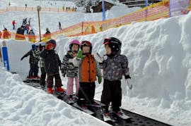 Kinderen vermaken zich op de converyor band tijdens hun Kinderskilessen (vanaf 3 jaar) voor beginners bij Schneesportschule ON SNOW Feldberg.