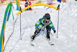 A kid whizzes around the fun obstacles during the Kids Ski Lessons (4-13 y.) for All Levels with Schneesportschule ON SNOW Feldberg.