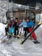 Un groupe de skieurs assis dans le télésiège et s'amusant pendant leurs Cours de ski Adultes (dès 14 ans) pour Tous Niveaux avec l'école de ski ON SNOW Feldberg.