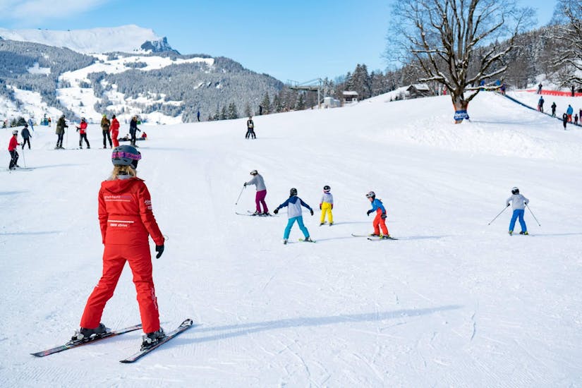 A family has fun at the "Family Fun Day" ski course with sledging with the Swiss Ski School Grindelwald.