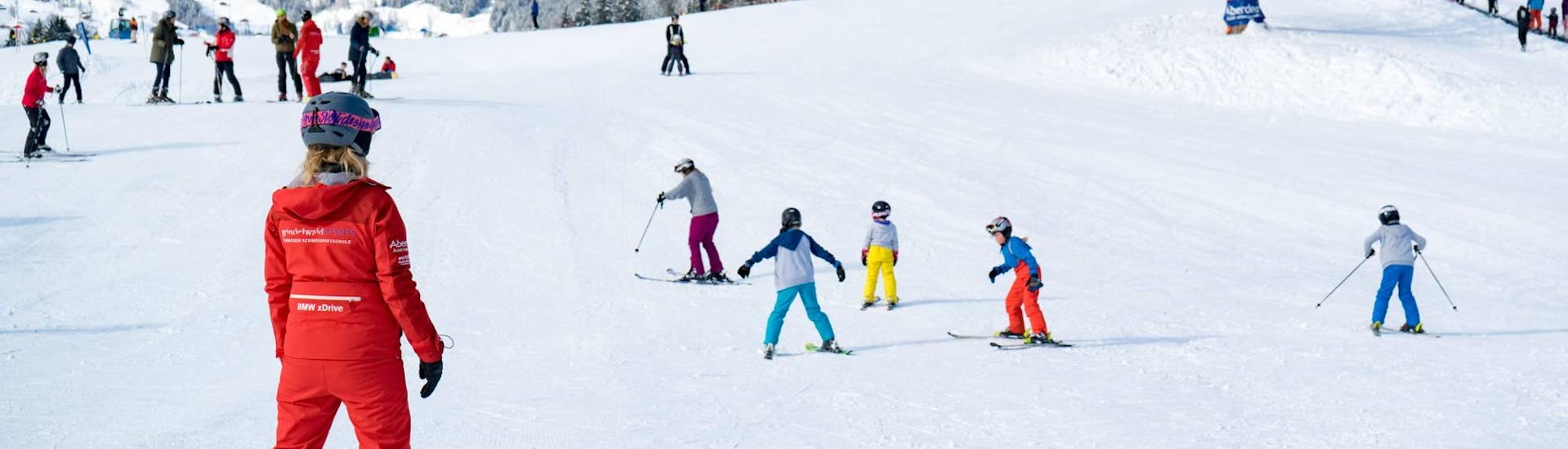 A family has fun at the "Family Fun Day" ski course with sledging with the Swiss Ski School Grindelwald.