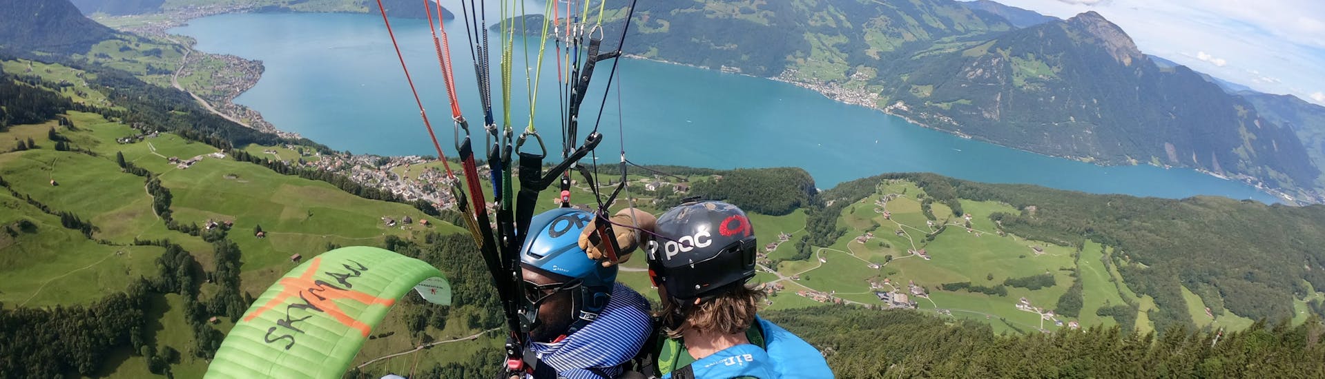 Zwei Personen fliegen im Tandem über den See beim Tandem Paragliding vom Niederbauen - Thermik mit SkyGlide Emmetten-Lucerne.