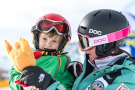 Un maestro accompagna un bambino durante le Lezioni di sci per bambini "Yeti Club" (3-5 anni) per principianti con Skischool Schlern 3000 Alpe di Siusi.