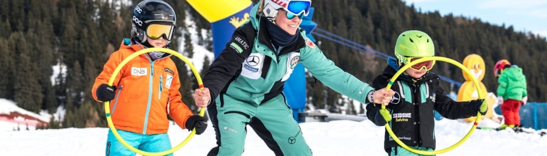 Dei bambini tengono dei cerchi durante le Lezioni di sci per bambini (6-14 anni) di tutti i livelli con Skischool Schlern 3000 Alpe di Siusi.