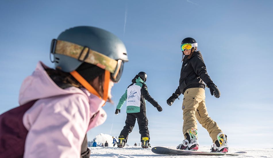 Snowboarders going down the slope during the Kids and Adult Snowboarding Lessons for All Levels with skischool Schlern 3000.