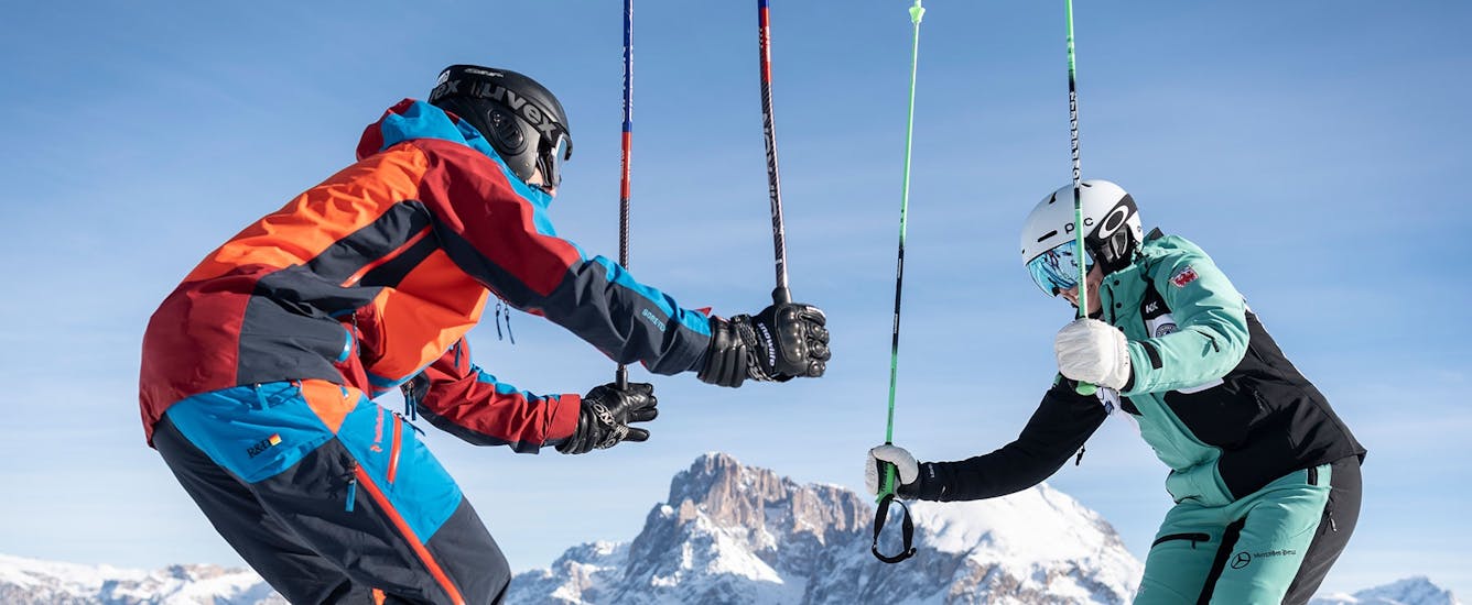 Two skiers holding up their poles during the Private Ski Lessons for Adults of All Levels with skischool Schlern 3000.