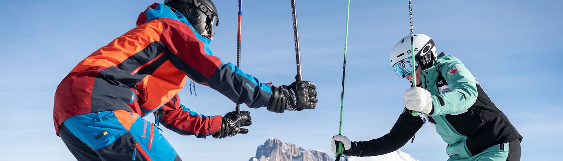 Skifahrer halten Skistöcke in die Luft während Privater Skikurs für Erwachsene aller Levels mit Skischule Schlern 3000.