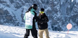 Snowboarder che si tengono stretti l'uno all'altro durante le Lezioni private di snowboard per tutte le età e livelli con Skischool Schlern 3000 Alpe di Siusi.