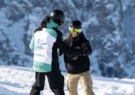 Snowboarders houden elkaar vast tijdens de privé snowboardlessen voor kinderen en volwassenen van alle niveaus met skischool Schlern 3000.