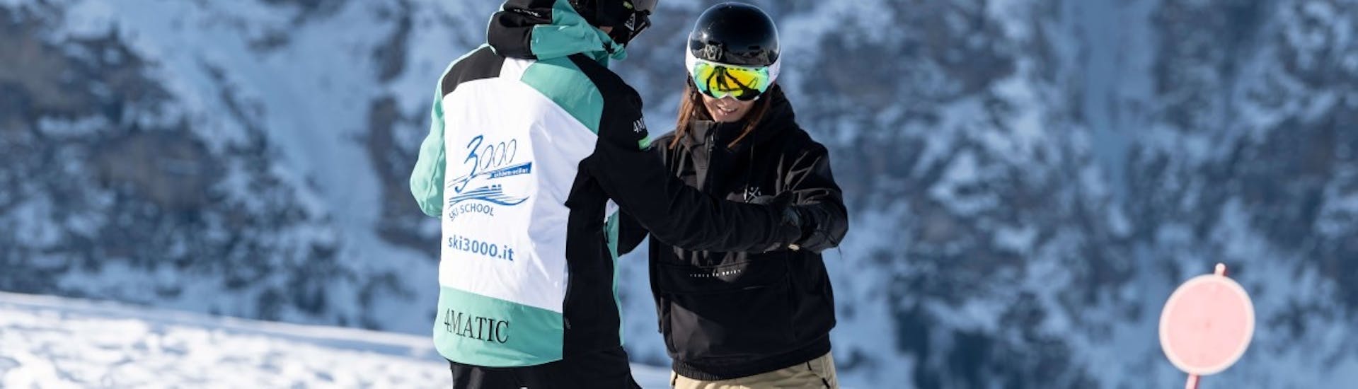 Snowboarders houden elkaar vast tijdens de privé snowboardlessen voor kinderen en volwassenen van alle niveaus met skischool Schlern 3000.