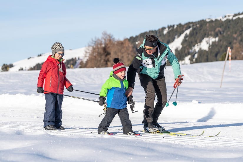 Kids and Instructor walking at trail during the Cross Country Skiing Lessons for All Levels with skischool Schlern 3000.