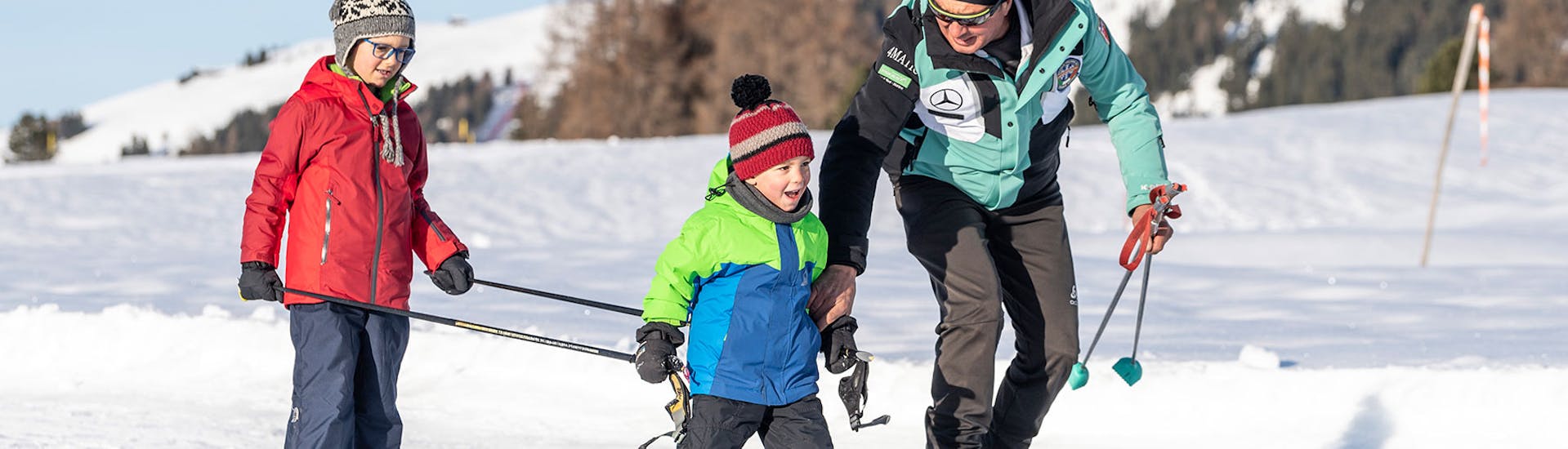 Kids and Instructor walking at trail during the Cross Country Skiing Lessons for All Levels with skischool Schlern 3000.
