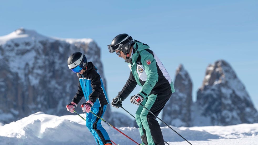 Skileraar en studenten hurken tijdens privé skilessen voor kinderen van alle niveaus - Saltria met skischool Schlern 3000.