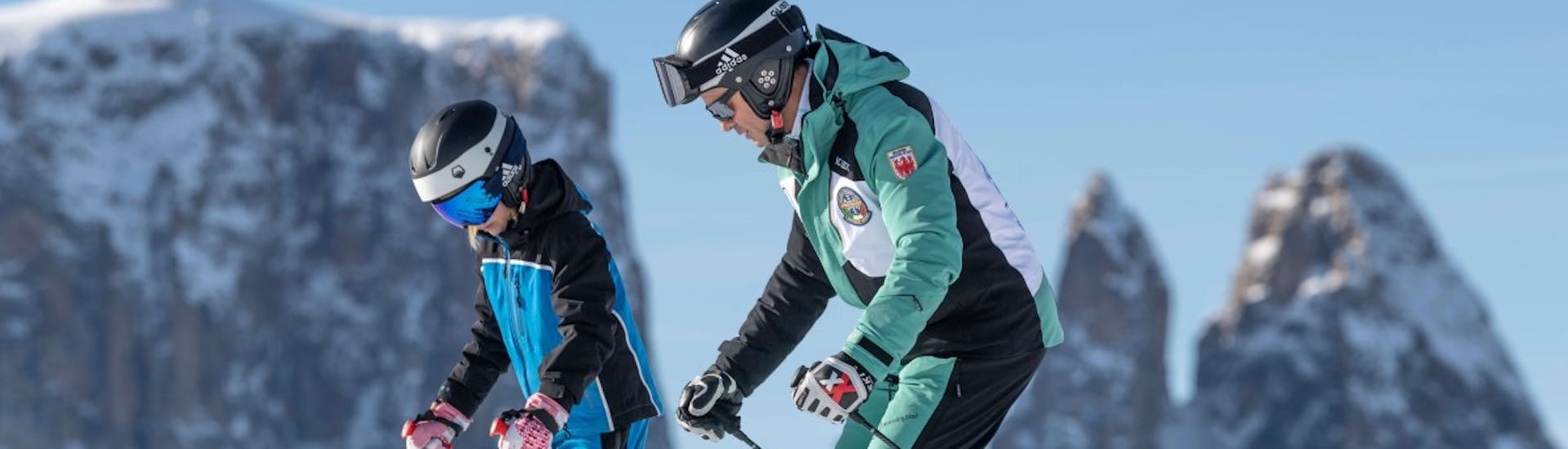 Skileraar en studenten hurken tijdens privé skilessen voor kinderen van alle niveaus - Saltria met skischool Schlern 3000.