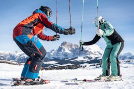 Maestro di sci e allievo in squat durante le lezioni private di sci per adulti di tutti i livelli - Saltria con la Skischool Schlern 3000.