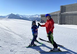 A kid is happy about his learnings from the kids ski lessons for beginners with Skischule Innsbruck.