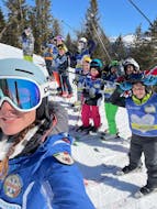 Alcuni bambini fanno un selfie con la loro maestra durante le Lezioni di sci per bambini (4-12 anni) per avanzati con Scuola Italiana Sci Marilleva.