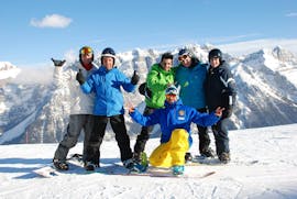 Some guys posing in front of the camera with their instructor during the Snowboarding Lessons (from 4 y.) for All Levels with Scuola Italiana Sci Marilleva.