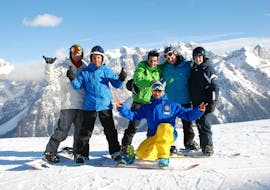 Alcuni ragazzi posano durante la fotocamera con il loro maestro durante le Lezioni di snowboard (dai 4 anni) per tutti i livelli con Scuola di Sci Marilleva.