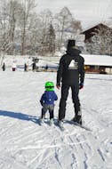 Een skileraar oefent de eerste rempogingen met een kind in privéskilessen voor kinderen (vanaf 3 jaar) van alle niveaus bij de skischool Bergsport JA Oberstdorf.