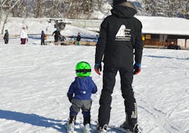 A ski instructor practises the first braking attempts with a child in a private kids ski lessons (from 3 years) of all levels with the ski school Bergsport JA Oberstdorf.