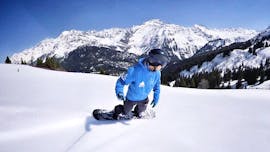 Ein Snowboarder fährt während seines privaten Snowboardkurses für Kinder und Erwachsene bei Freedom Snowsports Mont Blanc einen Hang hinunter.