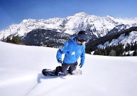 Ein Snowboarder fährt während seines privaten Snowboardkurses für Kinder und Erwachsene bei Freedom Snowsports Mont Blanc einen Hang hinunter.