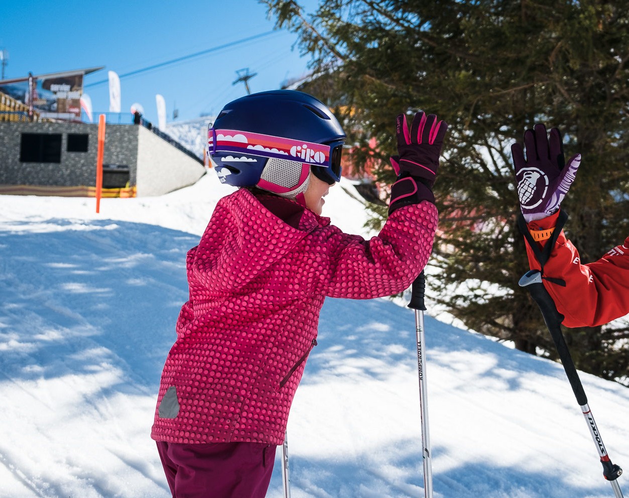 Child high-fives with ski instructor during the Private Ski Lessons for Kids of All Levels with Prime Mountain Sports Engelberg.
