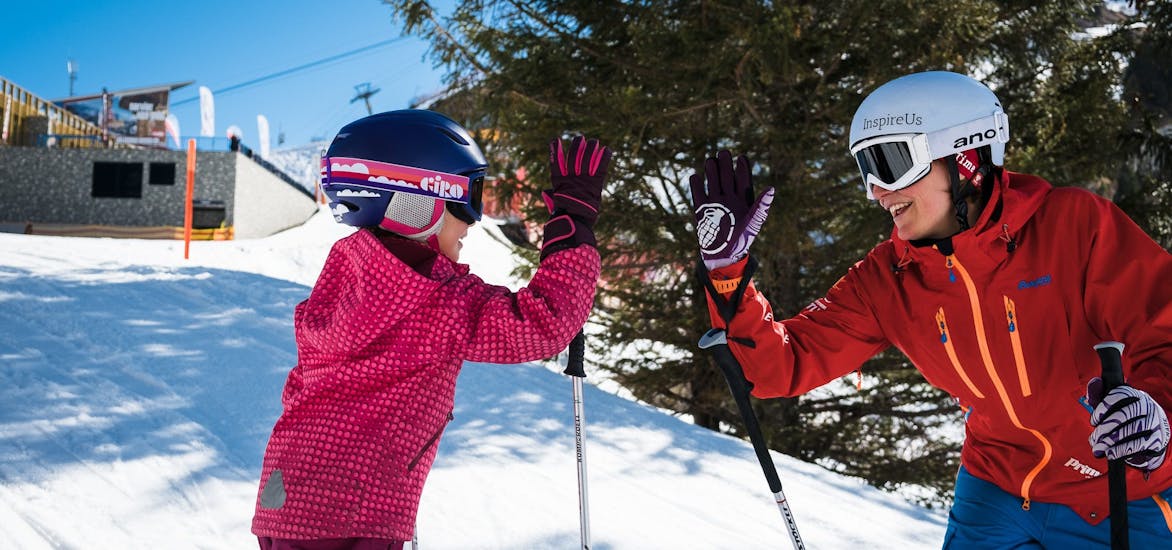 Child high-fives with ski instructor during the Private Ski Lessons for Kids of All Levels with Prime Mountain Sports Engelberg.