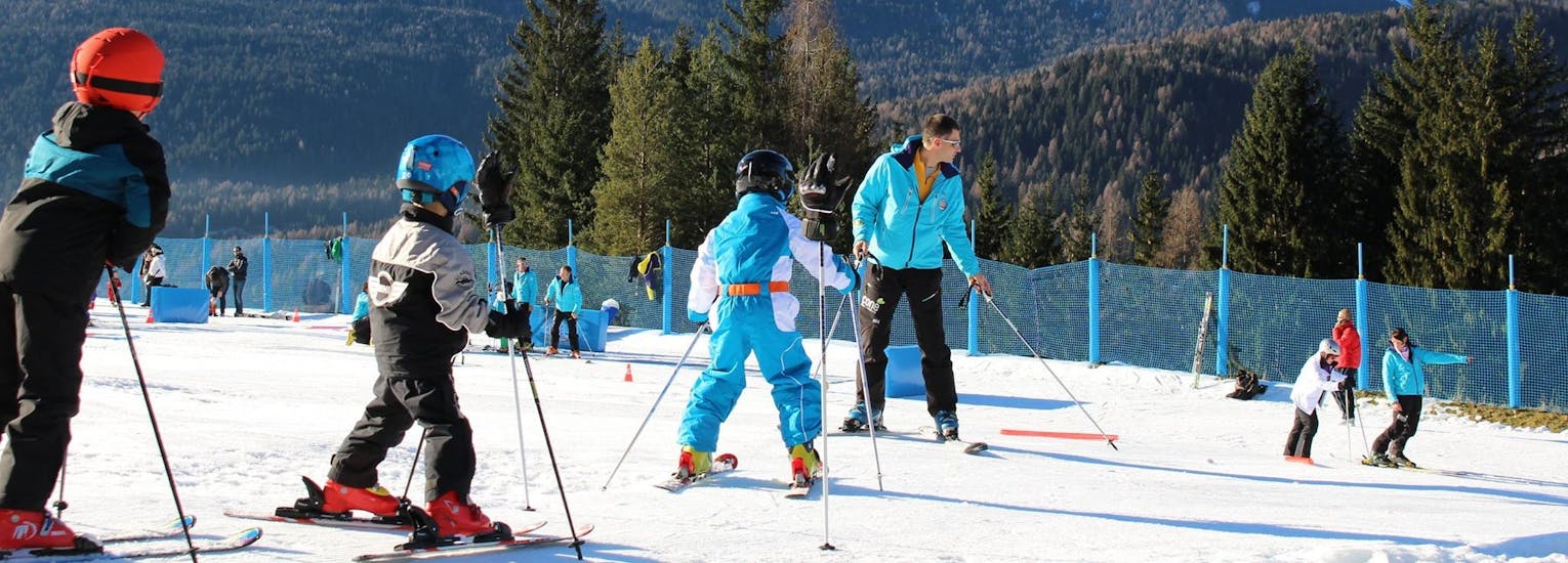 Three kids and an instructor during the Private Ski Lessons for Kids (from 3 y.) of All Levels with Scuola Sci Antelao San Vito di Cadore.