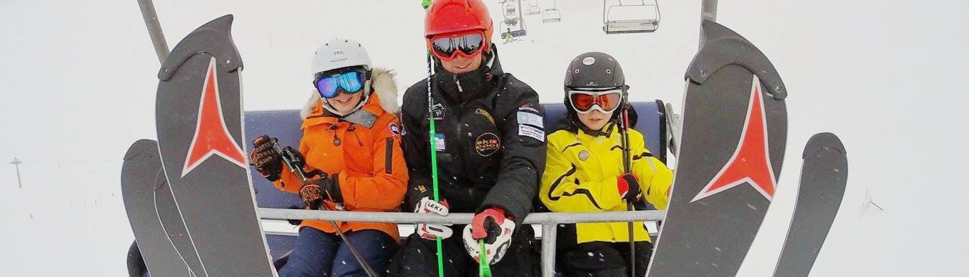 Instructor and students sitting in a chairlift during the Kids Ski Lessons (5-15 y.) for Experienced Skiers with Ski Cool St. Moritz.